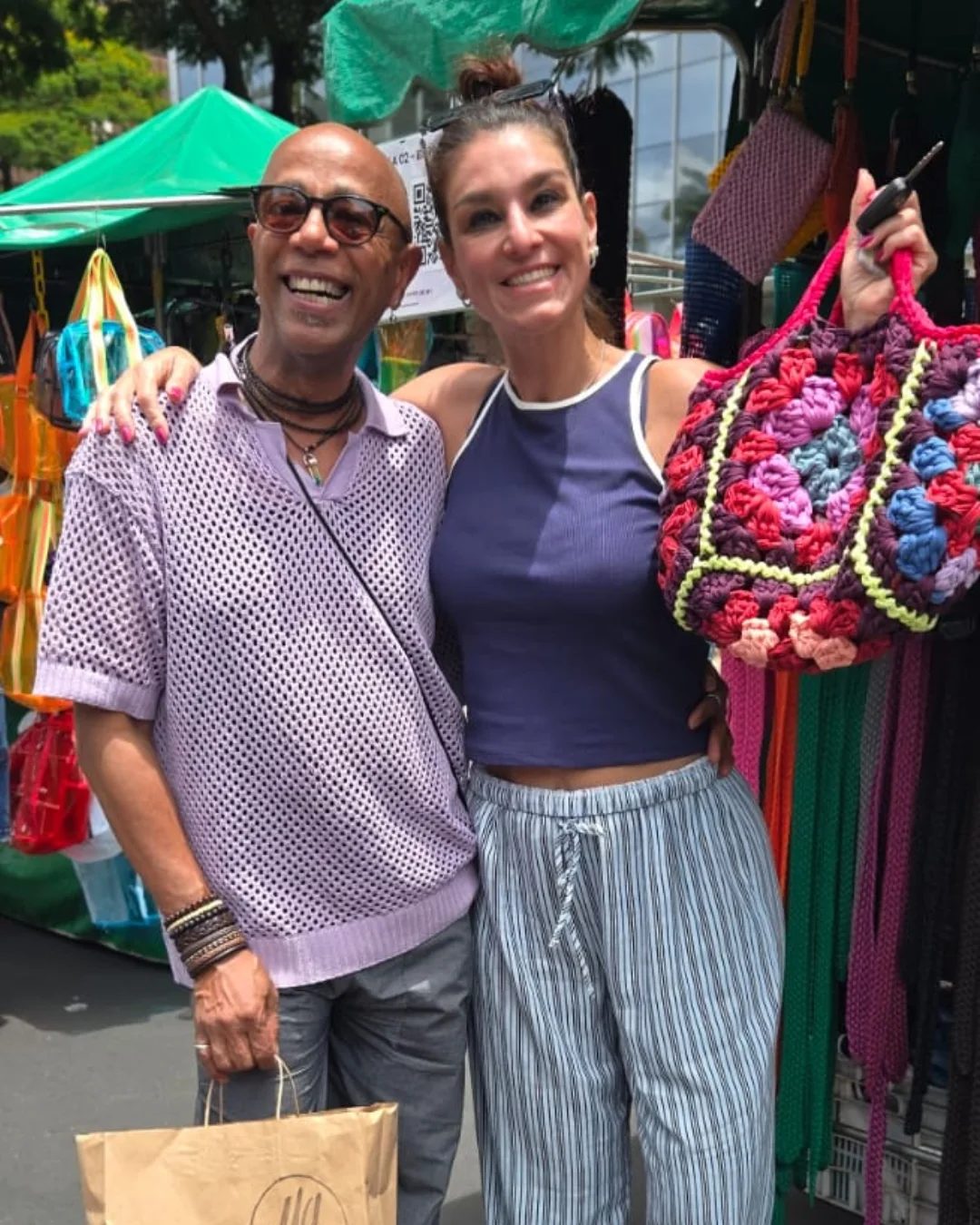 Casal na feira com uma bolsa de quadradinhos