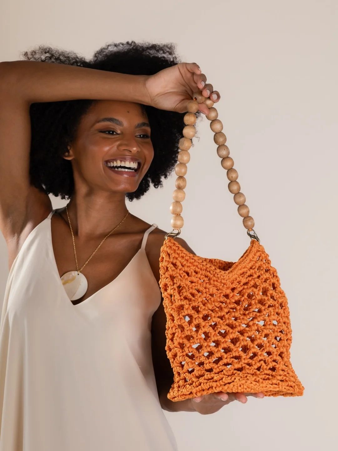 Cliente sorrindo com a bolsa Iracema laranja
